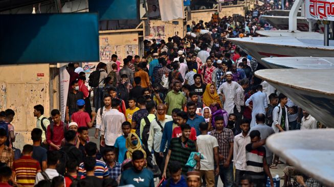 Orang-orang naik kapal feri untuk melakukan perjalanan mudik ke tempat asal mereka untuk merayakan Idul Fitri di Dhaka, Bangladesh, Sabtu (30/4/2022). [Munir uz Zaman / AFP]
