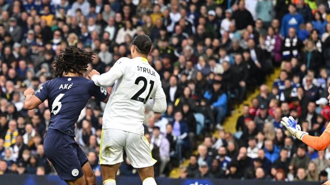 Bek Manchester City Nathan Ake (kiri) melakukan tendangan untuk mencetak gol saat pertandingan sepak bola Liga Premier Inggris antara Leeds United dan Manchester City di Stadion Elland Road, Leeds, Inggris, Sabtu (30/4/2022). [Oli SCARFF / AFP]