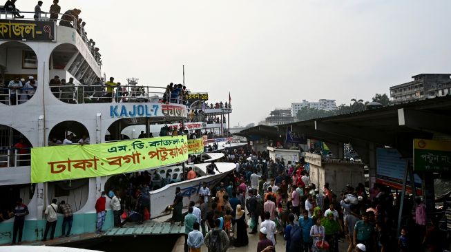 Orang-orang naik kapal feri untuk melakukan perjalanan mudik ke tempat asal mereka untuk merayakan Idul Fitri di Dhaka, Bangladesh, Sabtu (30/4/2022). [Munir uz Zaman / AFP]
