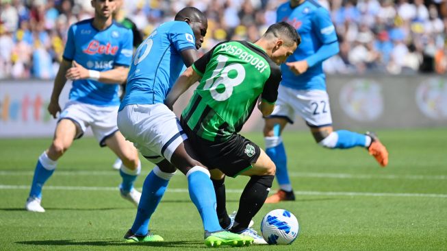 Bek Napoli Kalidou Koulibaly (kiri) berebut bola dengan pemain depan Sassuolo Giacomo Raspadori saat pertandingan sepak bola Serie A Liga Italia antara Napoli vs Sassuolo di stadion Diego Armando Maradona, Naples, Italia, Sabtu (30/4/2022). [Alberto PIZZOLI / AFP]