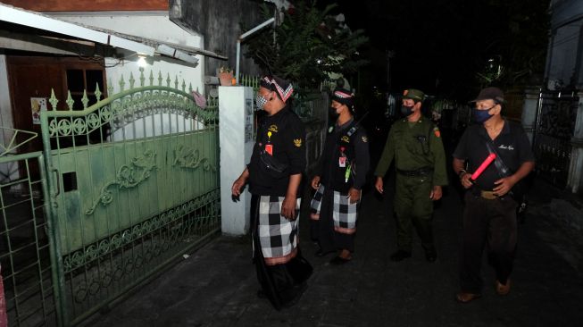 Pecalang bersama petugas Linmas memeriksa situasi rumah warga Muslim yang ditinggal mudik saat patroli di Denpasar, Bali, Sabtu (30/4/2022). [ANTARA FOTO/Nyoman Hendra Wibowo/hp]