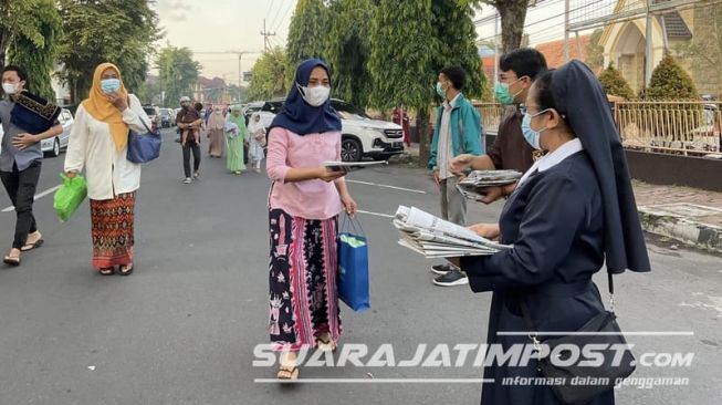 Umat Katolik bagikan koran bekas untuk warga Jember yang akan shalat Idulfitri. [Suarajatimpost.com]