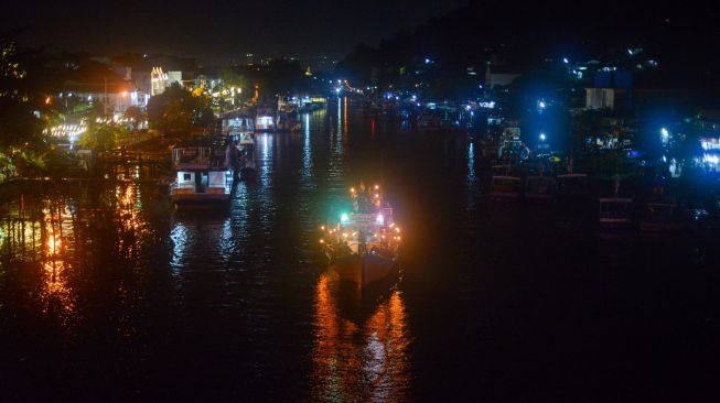 Sejumlah warga mengikuti pawai takbiran di atas kapal nelayan di kawasan kota tua Sungai Batang Arau, Padang, Sumatera Barat, Minggu (1/5/2022).  [ANTARA FOTO/Iggoy el Fitra/nz]