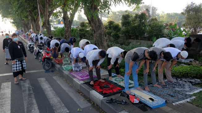 Pecalang atau satuan pengamanan desa adat Bali turut berjaga saat pelaksanaan Shalat Idul Fitri 1443 Hijriah di Lapangan Lumintang, Denpasar, Bali, Senin (2/5/2022).  [ANTARA FOTO/Nyoman Hendra Wibowo/hp]
