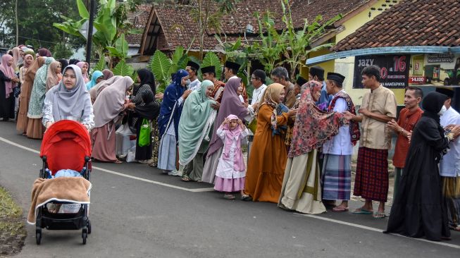 Sejumlah warga bersalaman usai melaksanakan salat Idul Fitri 1443 Hijriyah di Desa Darmaraja, Kabupaten Ciamis, Jawa Barat, Senin (2/4/2022). [ANTARA FOTO/Adeng Bustomi/hp]