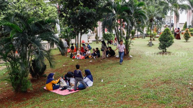 Pengunjung berwisata di Taman Mini Indonesia Indah, Jakarta Timur, Rabu (4/5/2022). [Suara.com/Alfian Winanto]