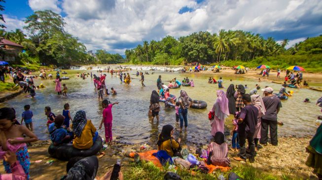 Wisatawan bermain air di wisata Manggasang di Kecamatan Hantakan, Kabupaten Hulu Sungai Tengah, Kalimantan Selatan, Selasa (3/5/2022). [ANTARA FOTO/Bayu Pratama S/wsj]
