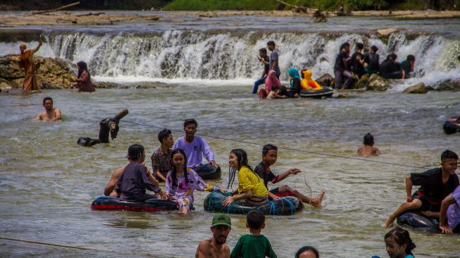 Wisatawan bermain air di wisata Manggasang di Kecamatan Hantakan, Kabupaten Hulu Sungai Tengah, Kalimantan Selatan, Selasa (3/5/2022). [ANTARA FOTO/Bayu Pratama S/wsj]