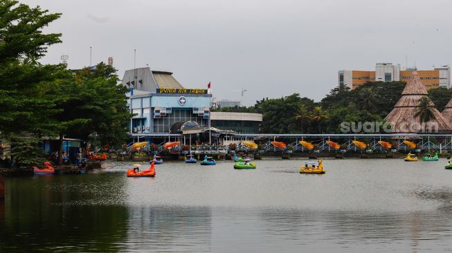 Pengunjung berwisata menaikin wahan air di Taman Mini Indonesia Indah, Jakarta Timur, Rabu (4/5/2022). [Suara.com/Alfian Winanto]