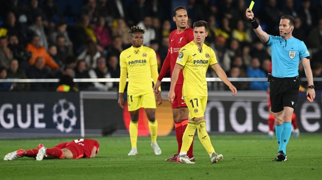 Gelandang Villarreal Giovani Lo Celso menerima kartu kuning kedua dari wasit Danny Makkelie setelah melanggar gelandang Liverpool Fabinho (kiri) saat pertandingan leg kedua semifinal UEFA Liga Champions antara Liverpool dan Villarreal di stadion La Ceramica, Villarreal, Spanyol, Selasa (3/5/2022). [Paul ELLIS / AFP]