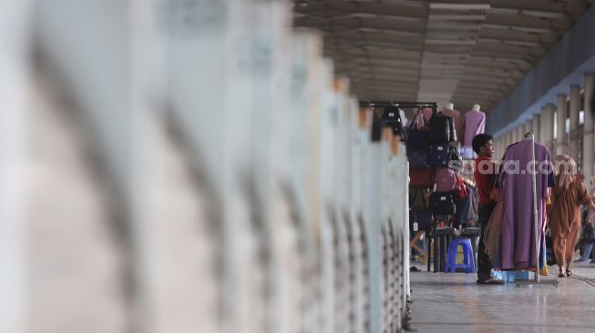 Pedagang menata pakaian di Skybridge Tanah Abang, Jakarta, Kamis (5/5/2022). [Suara.com/Angga Budhiyanto]