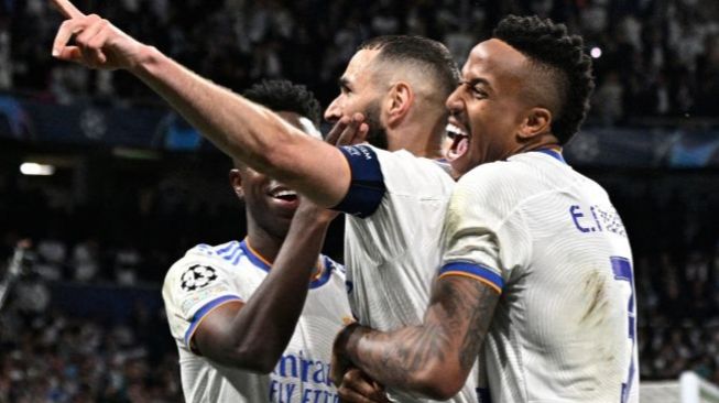 Pemain depan Real Madrid Karim Benzema (tengah) melakukan selebrasi dengan rekan setimnya Vinicius Junior (kiri) dan Eder Militao setelah usai mencetak gol saat pertandingan sepak bola leg kedua semifinal UEFA Liga Champions antara Real Madrid dan Manchester City di stadion Santiago Bernabeu, Madrid, Spanyol, Rabu (4/5/2022). [JAVIER SORIANO / AFP]