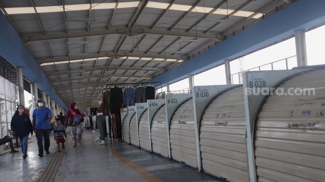 Warga berjalan melintasi deretan kios yang tutup di Skybridge Tanah Abang, Jakarta, Kamis (5/5/2022). [Suara.com/Angga Budhiyanto]