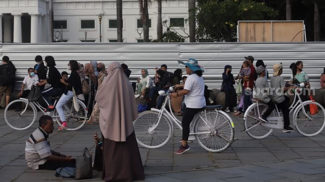 Warga berwisata di Taman Fatahillah, Kota Tua, Jakarta, Kamis (5/5/2022). [Suara.com/Angga Budhiyanto]