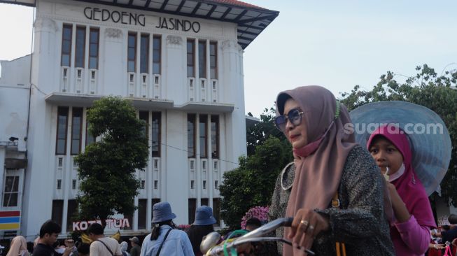 Warga menaiki sepeda saat berwisata di Taman Fatahillah, Kota Tua, Jakarta, Kamis (5/5/2022). [Suara.com/Angga Budhiyanto]