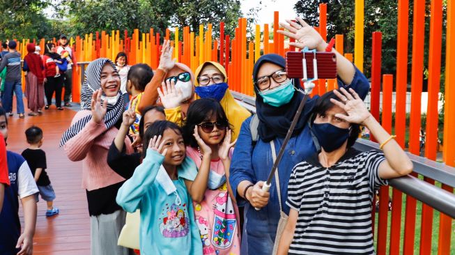 Warga berswafoto di area jembatan Tebet Eco Park, Jakarta Selatan, Kamis (5/5/2022). [Suara.com/Alfian Winanto]