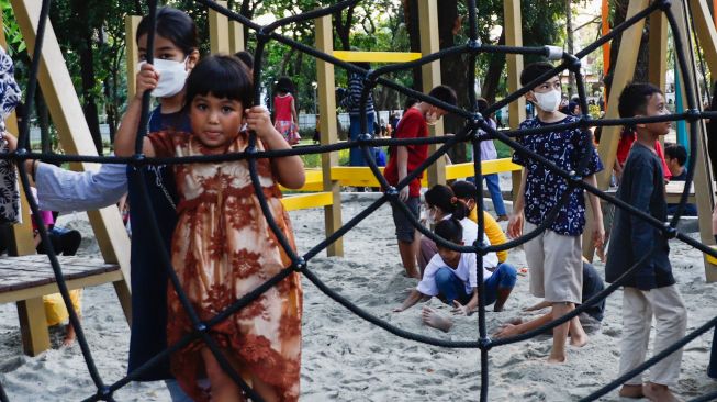 Anak-anak bermain saat berkunjung di Tebet Eco Park, Jakarta Selatan, Kamis (5/5/2022). [Suara.com/Alfian Winanto]