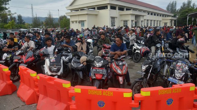 Sejumlah calon penumpang yang membawa kendaraan roda dua antre menunggu jadwal keberangkatan di pelabuhan penyeberangan Ulee Lheue, Banda Aceh, Aceh, Kamis (5/5/2022). [ANTARA FOTO/Ampelsa]