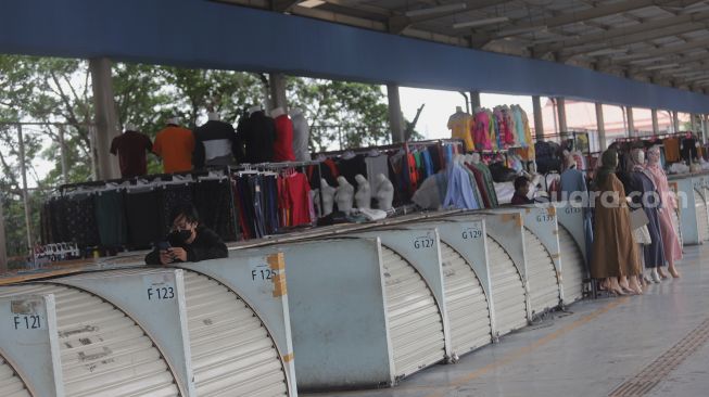Warga berdiri di dekat deretan kios yang tutup di Skybridge Tanah Abang, Jakarta, Kamis (5/5/2022). [Suara.com/Angga Budhiyanto]