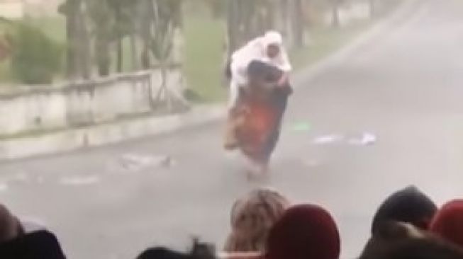 Pria Gendong Ibunya Berteduh dari Hujan Usai Salat Id, Warganet: Dia Membawa Surganya