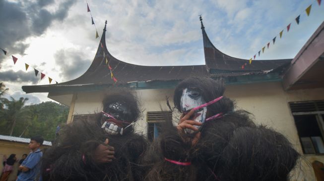 Dua warga berkostum "Simuntu" saat digelarnya Alek Anak Nagari Andaleh Baruah Bukik, Kabupaten Tanah Datar, Sumatera Barat, Rabu (4/5/2022). [ANTARA FOTO/Iggoy el Fitra/tom]
