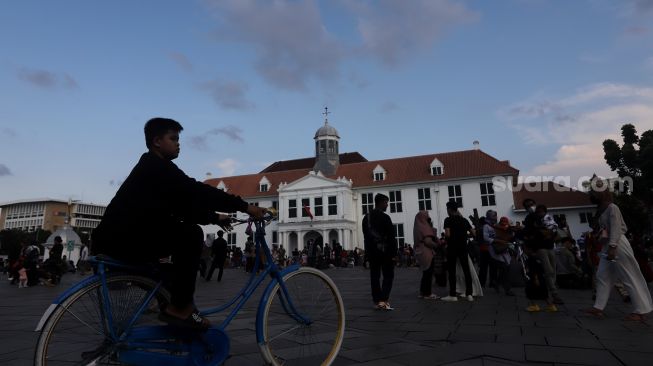 Warga berwisata di Taman Fatahillah, Kota Tua, Jakarta, Kamis (5/5/2022). [Suara.com/Angga Budhiyanto]