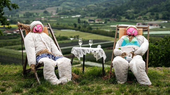 Dua orang-orangan sawah dipajang di ladang saat acara 'Pameran Orang-orangan Sawah' tahunan yang digelar di desa Castellar, Cuneo, Italia, Selasa (3/5/2022). [MARCO BERTORELLO / AFP]
