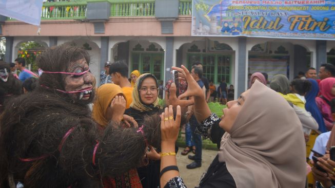 Pengunjung berswafoto bersama "Simuntu" saat digelarnya Alek Anak Nagari Andaleh Baruah Bukik, di Kabupaten Tanah Datar, Sumatera Barat, Rabu (4/5/2022). [ANTARA FOTO/Iggoy el Fitra/tom]

