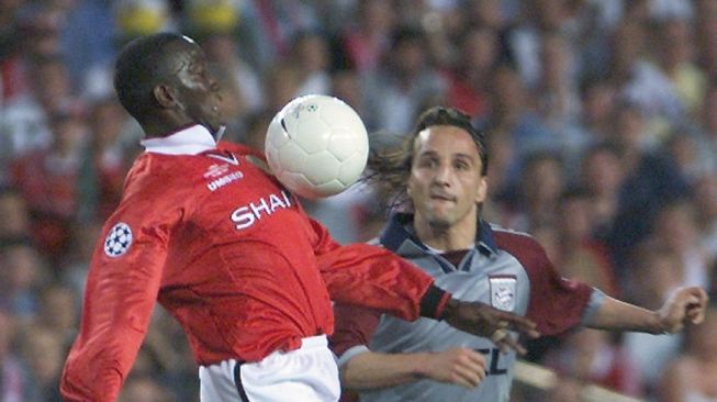 Pemain depan Manchester United Dwight Yorke (kiri) ditantang gelandang Bayern Munich Jens Jeremies pada laga final Liga Champions 1998/1999 di Stadion Camp Nou di Barcelona. Manchester United menang 2-1 dalam laga ini.Patrick HERTZOG / AFP.