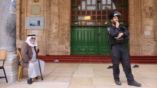 Seorang polisi Israel berjaga-jaga selama kunjungan sekelompok orang Yahudi di kompleks Masjid Al-Aqsa di Yerusalem, pada (5/5/2022). [AHMAD GHARABLI / AFP]