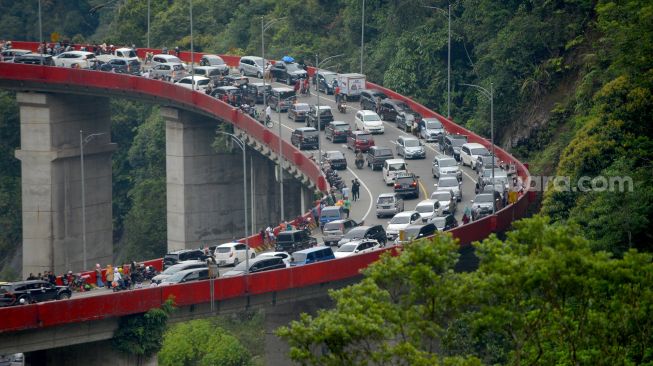 Sejumlah kendaraan melewati Fly Over Kelok Sembilan, Kabupaten Limapuluhkota, Sumatera Barat, Kamis (5/5/2022). [ANTARA FOTO/Iggoy el Fitra]