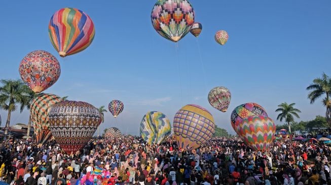 Warga menyaksikan Festival Balon Tradisional di lapangan Kembaran, Kalikajar, Wonosobo, Jawa Tengah, Jumat (6/5/2022). [ANTARA FOTO/Anis Efizudin]