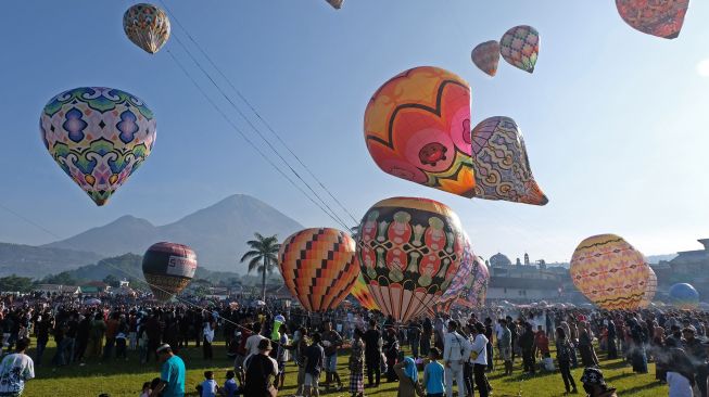 Warga menyaksikan Festival Balon Tradisional di lapangan Kembaran, Kalikajar, Wonosobo, Jawa Tengah, Jumat (6/5/2022). [ANTARA FOTO/Anis Efizudin]