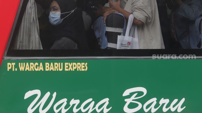 Pemudik bersiap turun dari bus setibanya di Terminal Kampung Rambutan, Jakarta, Sabtu (7/5/2022). [Suara.com/Angga Budhiyanto]