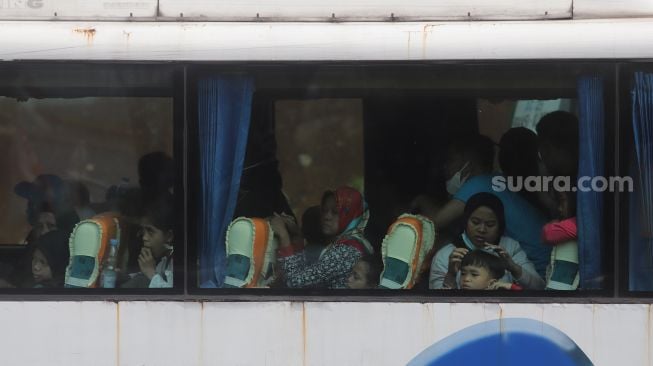 Sejumlah penumpang beraktivitas di dalam bus yang terjebak kemacetan di Jalan Raya Kalimalang, Bekasi, Jawa Barat, Sabtu (7/5/2022). [Suara.com/Angga Budhiyanto]