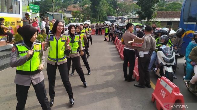 Sejumlah anggota polisi wanita berjoget untuk menghibur pemudik di depan Pos Pengamanan Mudik Cikaledong, Nagreg, Kabupaten Bandung, Jawa Barat, Ahad (8/5/2022). (ANTARA/Bagus Ahmad Rizaldi)