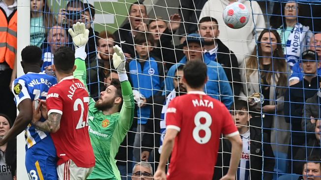 Kiper Manchester United David de Gea gagal menghalau tendangan dari bek Brighton Marc Cucurella sehingga berbuah gol saat pertandingan sepak bola Liga Premier Inggris antara Brighton dan Manchester United di Stadion American Express Community, Brighton, Inggris, Sabtu (7/5/2022). [Glyn KIRK / AFP]
