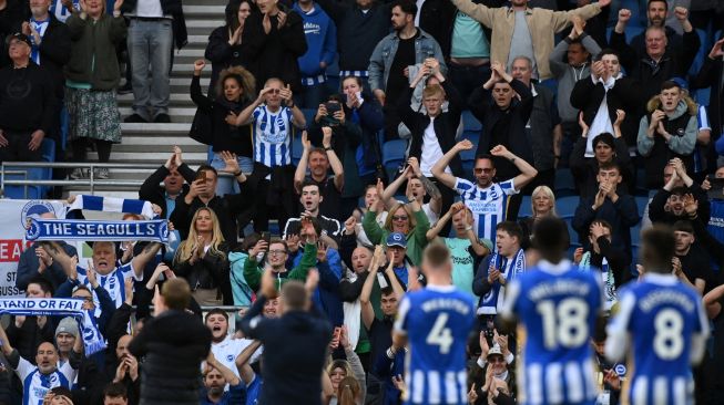 Para pemain Brighton merayakan kemenangan dengan pendukung mereka usai pertandingan sepak bola Liga Premier Inggris antara Brighton dan Manchester United di Stadion American Express Community, Brighton, Inggris, Sabtu (7/5/2022). [Glyn KIRK / AFP]
