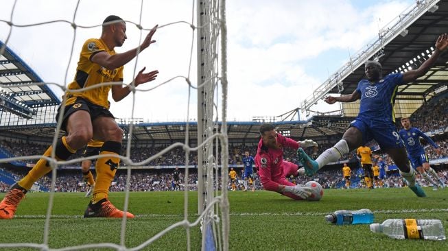 Striker Chelsea Romelu Lukaku (kanan) gagal mencetak gol melewati kiper Wolverhampton Wanderers Jose Sa saat pertandingan sepak bola Liga Premier Inggris antara Chelsea dan Wolverhampton Wanderers di Stadion Stamford Bridge, London, Inggris, Sabtu (7/5/2022). [JUSTIN TALLIS / AFP]