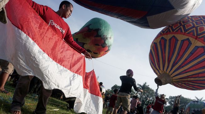 Sejumlah warga menerbangkan balon udara yang ditambatkan di tanah saat "Balloon Attraction Pekalongan 2022" di Lapangan Mataram, Kota Pekalongan, Jawa Tengah, Minggu (8/5/2022). [ANTARA FOTO/Harviyan Perdana Putra/aww]
