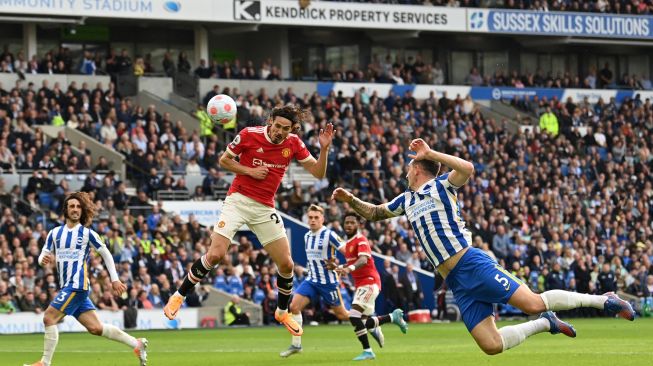 Striker Manchester United Edinson Cavani (tengah) menyundul bola saat pertandingan sepak bola Liga Premier Inggris antara Brighton dan Manchester United di Stadion American Express Community, Brighton, Inggris, Sabtu (7/5/2022). [Glyn KIRK / AFP]