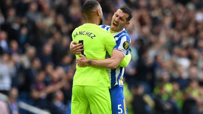 Bek Brighton Lewis Dunk (kanan) merayakan dengan kiper Brighton Robert Sanchez (kiri) usai mencetak gol saat pertandingan sepak bola Liga Premier Inggris antara Brighton dan Manchester United di Stadion American Express Community, Brighton, Inggris, Sabtu (7/5/2022). [Glyn KIRK / AFP]