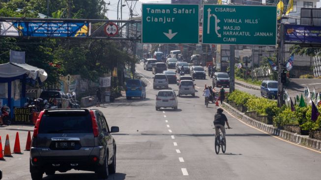 Sejumlah kendaraan melintas di Jalan Raya Puncak, Gadog, Ciawi, Kabupaten Bogor, Jawa Barat, Minggu (8/5/2022). [ANTARA FOTO/Yulius Satria Wijaya/aww]