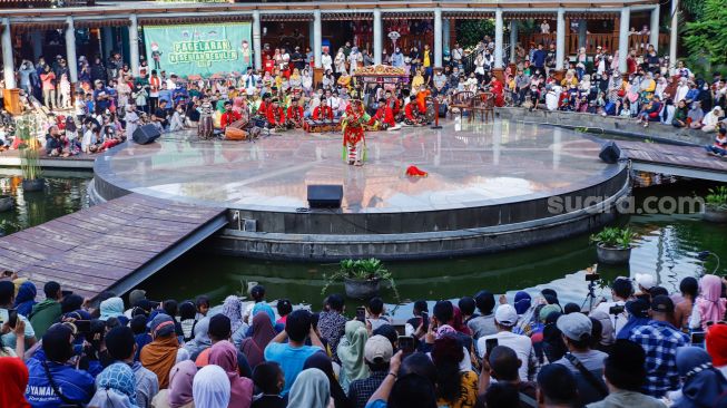 Para penonton menyaksikan pertunjukan Tari Topeng Betawi di Perkampungan Budaya Betawi Setu Babakan, Jagakarsa, Jakarta Selatan, Minggu (8/5/2022). [Suara.com/Alfian Winanto]