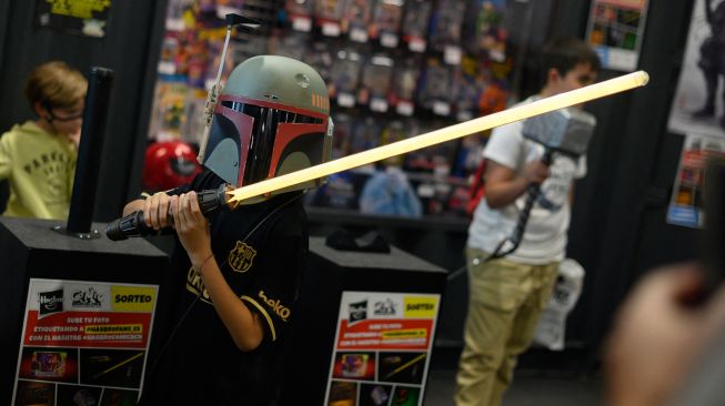 Seorang pengunjung berdandan seperti karakter Boba dalam film Star Wars saat menghadiri Comic Fair ke-40 di Barcelona, Spanyol, Sabtu (7/5/2022). [Josep LAGO / AFP]