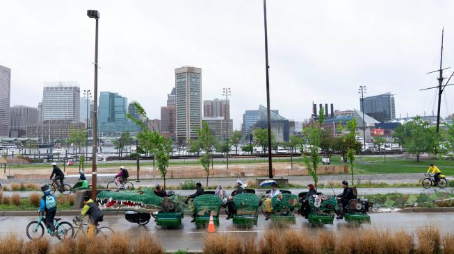 Para peserta mengayuh patung kinetik mereka saat ajang Lomba Balap Patung Kinetik yang digelar Museum Seni Visioner Amerika di Pelabuhan Baltimore, Maryland, Amerika Serikat, Sabtu (7/5/2022). [Jose Luis Magana / AFP]