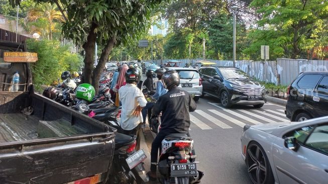 Banyak parkir liar gegara jumlah pengunjung Tebet Eco Park di Jakarta Selatan membludak saat libur lebaran 2022. (Suara.com/Fakhri Fuadi)