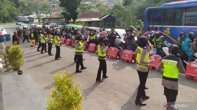 Sejumlah anggota Polisi Wanita berjoget untuk menghibur pemudik di depan Pos Pengamanan Mudik Cikaledong, Nagreg, Kabupaten Bandung, Jawa Barat, Ahad (8/5/2022). (ANTARA/Bagus Ahmad Rizaldi)