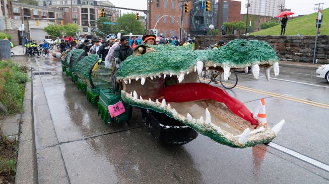 Para peserta mengayuh patung kinetik mereka saat ajang Lomba Balap Patung Kinetik yang digelar Museum Seni Visioner Amerika di Pelabuhan Baltimore, Maryland, Amerika Serikat, Sabtu (7/5/2022). [Jose Luis Magana / AFP]