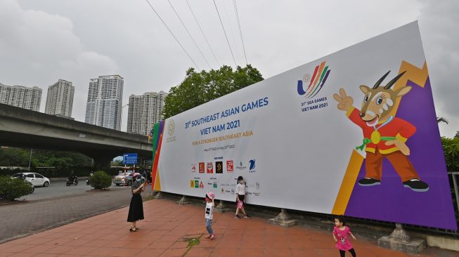 Seorang ibu dan anak-anaknya Germaine di depan gambar maskot SEA Games 2021 Vietnam, Hanoi Saola, di Kota Hanoi, Vietnam, Minggu (8/5/2022). [ANTARA FOTO/Aditya Pradana Putra/YU]